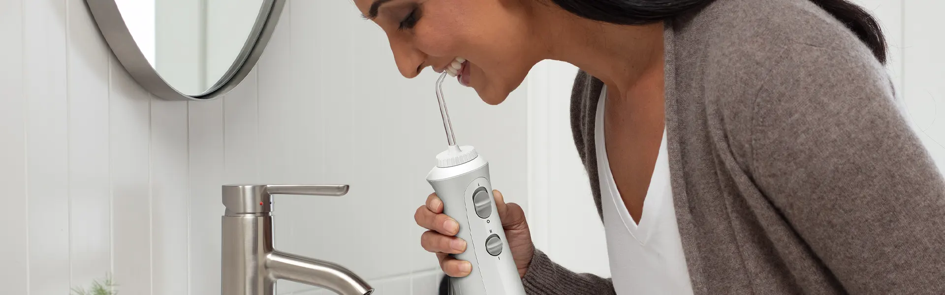 Mujer utilizando irrigador dental Waterpik